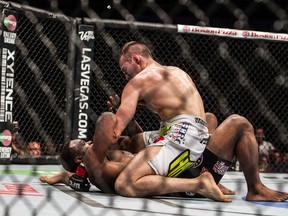 Rory MacDonald punches while on top of Tyron Woodley during UFC 174 welterweight bout at Rogers Arena in Vancouver, B.C. on June 14, 2014. (Carmine Marinelli /QMI Agency)