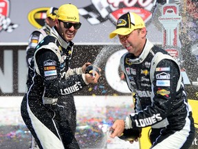 Jimmie Johnson (left) celebrates with crew chief Chad Knaus in Victory Lane after winning the NASCAR Sprint Cup Series Quicken Loans 400 at Michigan International Speedway on Sunday. (Patrick Smith/Getty Images/AFP)