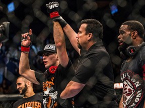 Canadian mixed martial artist Rory MacDonald (left) has his arm raised by the ref after defeating Tyron Woodley in their welterweight bout at UFC 174 on Saturday night in Vancouver. (Carmine Marinelli /QMI Agency)