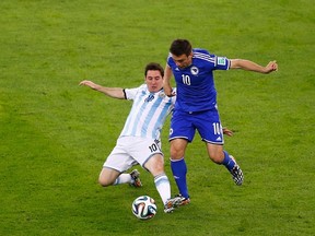 Argentina's Lionel Messi fights for the ball with Bosnia's Zvjezdan Misimovic during their 2014 World Cup Group F soccer match at the Maracana stadium in Rio de Janeiro on June 15, 2014. (REUTERS/Ricardo Moraes)
