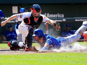 Orioles catcher Nick Hundley applies the tag on Blue Jays’ Jose Bautista at home plate during the eighth inning on Sunday at Oriole Park at Camden Yards in Baltimore. Bautista was called out and the ruling held up after being challenged by Toronto. (AFP/PHOTO)