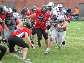 Cornwall defenders Joel Cloutier (18) and Cullen Jacobs (88) look to stop Kingston ball carrier Liam Brand in OVFL play Saturday. The Wildcats got a late field goal and edged Kingston 17-16. (Todd Hambleton/QMI Agency)