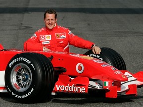 Michael Schumacher of Germany poses with the new Ferrari Formula One race car 248 F1 during the official presentation at the Mugello racetrack in Scarperia, central Italy, in this January 24, 2006 file photo. (REUTERS/Tony Gentile/Files)