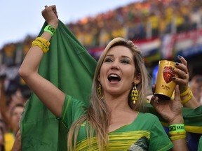 Brazilian fans cheer their team prior to a Group A football match between Brazil and Croatia at the Corinthians Arena in Sao Paulo during the 2014 FIFA World Cup on June 12, 2014. (AFP PHOTO / FABRICE COFFRINI)