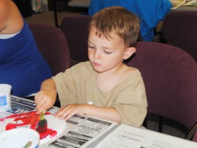 Bennett Lenko, 2 1/2 works on a special present for his father during the Whitecourt and District Public Library's story time on Saturday, June 14. 
Barry Kerton | Whitecourt Star