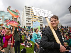 Demonstrators carry signs in protest against the Northern Gateway pipeline project during a "no" to the Enbridge pipeline rally at English Bay in Vancouver, British Columbia May 10, 2014. (REUTERS/Ben Nelms)