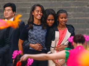 U.S. first lady Michelle Obama (C) hugs her daughters Malia (2nd L) and Sasha (R).

REUTERS/Petar Kujundzic