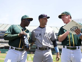Oakland Athetics’ Chili Davis (left) and manager Bob Melvin (right) present Yankees’ Derek Jeter with gifts prior to Sunday’s game. (AFP/PHOTO)