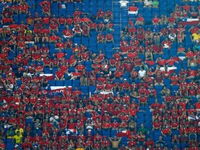 Fans are surrounded by empty seats during the World Cup match between Chile and Australia at the Pantanal arena in Cuiaba June 13, 2014. (REUTERS/Eddie Keogh)