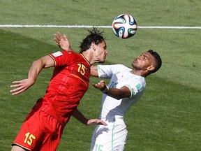 Belgium's Daniel Van Buyten (left) and Algeria's El Arabi Soudani fight for the ball during their  World Cup match at the Mineirao stadium in Belo Horizonte June 17, 2014. (REUTERS/Leonhard Foeger)