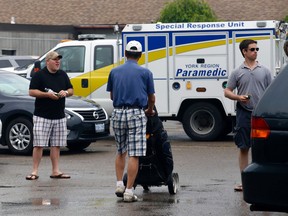 Golfers mingle in the parking lot after four golfers were struck by lightning at Rolling Hills golf course in Stouffville on Tuesday June 17, 2014. (Michael Peake/Toronto Sun)