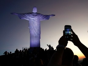A tourist takes a picture of the statue of Christ the Redeemer ahead of the 2014 World Cup in Rio de Janeiro June 8, 2014.  (REUTERS/Eddie Keogh)