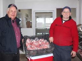 Lambton Cattlemen's Association president Tom Lassaline, left, and Doug Waller of Lambton Meats load up their donation of nearly 200 pounds of ground beef to local food banks.
