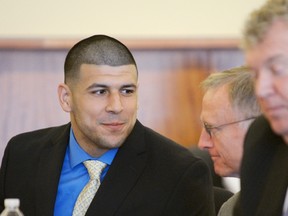 Former New England Patriots tight end Aaron Hernandez talks with his defence attorney, Charles Rankin (middle), during a hearing at the Bristol County Superior Court House in Fall River, Mass., June 16, 2014. (REUTERS/Faith Ninivaggi/POOL)