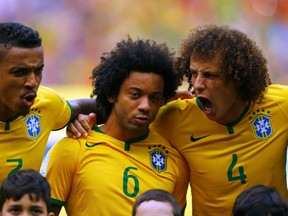 Brazil's Luiz Gustavo, Marcelo and David Luiz sing the national anthem before the 2014 World Cup Group A soccer match between Brazil and Mexico at the Castelao arena in Fortaleza June 17, 2014. (REUTERS/Marcelo Del Pozo)