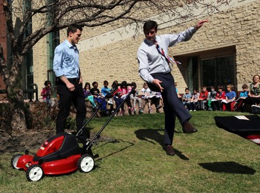 Don Iveson kicks away the lawnmower bag during anews conference.  Mayor Don Iveson and Edmonton OIler Andrew Ference mows the grass at City Hall in Edmonton, Alberta on Monday, May 12, 2014.  The city wants to encourage homeowners to go bagless when they cut their grass.   Perry Mah/ Edmonton Sun/ QMI Agency