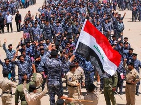 Volunteers, who have joined the Iraqi security forces to fight against the predominantly Sunni militants from the radical Islamic State of Iraq and the Levant (ISIL), wearing police forces uniforms gather in the holy city of Najaf, June 18, 2014.   REUTERS/ Alaa Al-Marjani