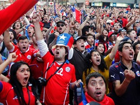 Fans of Chile celebrate their team's victory over Spain in their 2014 World Cup Group B soccer match at a public screening in downtown Santiago June 18, 2014.  (REUTERS)
