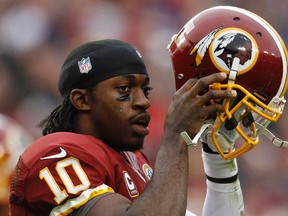 Redskins quarterback Robert Griffin III puts his helmet back on after being tackled by the Ravens defenCe during NFL action in 2012. (Gary Cameron/Reuters/Files)