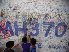 Children write messages of hope for passengers of missing Malaysia Airlines Flight MH370 at Kuala Lumpur International Airport (KLIA) outside Kuala Lumpur June 14, 2014. Sunday marks the 100th day that the flight from Kuala Lumpur to Beijing disappeared with 239 passengers and crew on board. REUTERS/Samsul Said