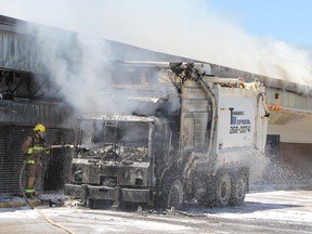 A Timmins firefighter extinguishes a truck fire, which spread to the Porcupine Mall, on Thursday afternoon.