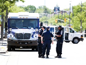 Police collect evidence at the scene of a shooting after an attempted robbery of an armoured GardaWorld truck on Avenue Road, north of Lawrence Avenue, on Thursday, June 19, 2014. (VERONICA HERNI/Toronto Sun)