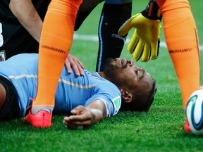 Uruguay's Alvaro Pereira is attended to after taking a knee to the head by England's Raheem Sterling during their World Cup match at the Corinthians arena in Sao Paulo on Thursday, June 19, 2014. (Damir Sagolj/Reuters)