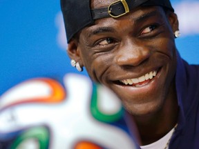 Italy's national soccer team player Mario Balotelli smiles while answering a question during an news conference at the Pernambuco arena in Recife, June 19, 2014. (REUTERS/Brian Snyder)