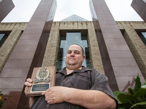 Cab driver Ken Thomas poses for a photo with his award, received from Edmonton Police Service chief Rod Knecht, outside of City Hall in Edmonton, Alta., on Thursday, June 19, 2014. Thomas was instrumental in assisting police in two separate drinking and driving incidents. Ian Kucerak/Edmonton Sun/QMI Agency