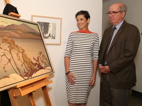 JOHN LAPPA/THE SUDBURY STAR
Josee Forest-Niesing, vice-president of the board of the Art Gallery of Sudbury, and Tom Smart, deputy director and curator of the art gallery, unveil seven paintings donated by the family of Franklin Carmichael at the launch of the Festival of the Seven at the art gallery on Thursday, June 19, 2014. Forest-Niesing has just won the  volunteer of the year award from the Ontario Association of Art Galleries