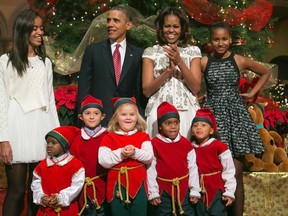 U.S. President Barack Obama (2nd L), his wife Michelle (2nd R) and their daughters Malia (top L) and Sasha (top R) are greeted by a team of elves made up of former patients of the Children's National Medical Center, as the Obamas arrive for a taping of the Christmas in Washington television benefit program at the National Building Museum in Washington in this December 15, 2013 file photo. (REUTERS/Jonathan Ernst)
