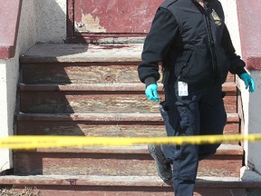 A police ident officer walks past a pool of blood at a multiplex housing unit at Martha and Disraeli following a serious assault in Winnipeg, Man. Sunday March 31, 2013.
BRIAN DONOGH/WINNIPEG SUN/QMI AGENCY