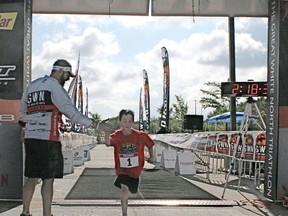 Race director Michael Brown welcomes a youngster completing the Kids 1K Fun Run at the Great White North triathlon last year. The event will be back again this year and is open to any youth aged four to 14, who can be accompanied by their parent(s) if need be. - Gord Montgomery, Reporter/Examiner