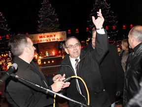 Veteran city councillor Garnet Thompson, right, is seen here as he flips the switch on Belleville's Christmas at the Pier Light Display at Jane Forrester Park in November 2012. - File photo by Jerome Lessard/The Intelligencer