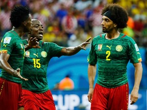 Cameroon's Achille Weboc (centre) tries to separate teammates Benjamin Moukandjo (left) and Benoit Assou-Ekotto (right) as they argue during their World Cup match against Croatia at the Amazonia arena in Manaus, Brazil on Wednesday, June 18, 2014. (Murad Sezer/Reuters)