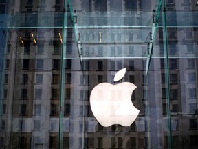 The Apple logo hangs inside the glass entrance to the Apple Store on 5th Avenue in New York City, in this April 4, 2013, file photo. REUTERS/Mike Segar/Files