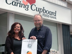 Caring Cupboard Food Bank general manager Karen McDade and CTP Computer and Network Services owner Sandy Vazquez hold a poster outside the food bank on Talbot St. Posters like this will be going up around the city to raise awareness of poverty in St. Thomas and to encourage people to donate to a campaign to raise $60,000 for Caring Cupboard over the next three years. Ben Forrest/Times-Journal