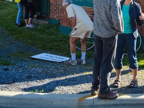 Supporters place signs outside the former Bailey Broom Company building to protest its planned demolition. (Alex Pickering/For The Whig-Standard)