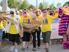 Cancer survivors break through a paper barrier marking the beginning of the Survivors' Lap kicking off the Belleville Relay for Life held at Loyalist College Friday. This year's event was themed Storybook Land and participants were encouraged to dress up. The 12-hour event raises money for the Canadian Cancer Society and brings cancer survivors and fighters together with the friends, family and caregivers to celebrate victories and remember those who have died from cancer. 
Emily Mountney/The Intelligencer
