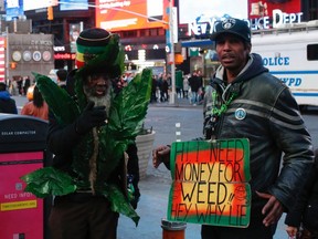 A man dressed as a marijuana leaf stands with another with a poster, as they ask for money to buy pot at Times Square in New York, March 22, 2014. (REUTERS/Eduardo Munoz)