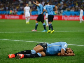 Uruguay's Alvaro Pereira lies injured on the pitch after being hit in the head by the knee of England's Raheem Sterling during their World Cup match at the Corinthians arena in Sao Paulo on Thursday, June 19, 2014. (Damir Sagolj/Reuters)