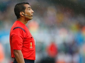 Linesman Humberto Clavijo of Colombia looks on after signalling an offside during the 2014 World Cup Group A soccer match between Mexico and Cameroon at the Dunas arena in Natal June 13, 2014. (REUTERS/Toru Hanai)