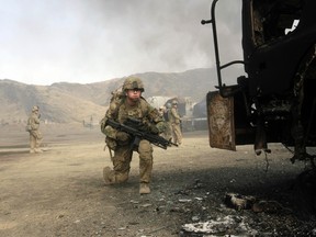 U.S. soldiers arrive at the site of burning NATO supply trucks after an attack by militants in the Torkham area near the Pakistani-Afghan in Nangarhar Province June 19, 2014. (REUTERS/ Parwiz)