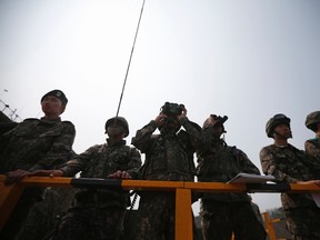 South Korean army soldiers look at the mock target through their binoculars during a U.S.-South Korea joint live-fire military exercise at a training field in Pocheon, south of the demilitarized zone separating the two Koreas, April 11, 2014. REUTERS/Kim Hong-Ji