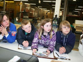 Woodlands School science and technology teacher Maria Nikkel with Brant-Argyle School students Ryan Petricig, Avery Good and Ethan Enns get a look at their experiment after it returned from the ISS.