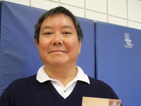 Sensei Bob Sing holds up a photo of his 23-year-old self receiving his black belt in 1976. The now 61-year-old Sarnia judo instructor was recognized Saturday for his commitment to the sport and to the YMCA. BARBARA SIMPSON/THE OBSERVER/QMI AGENCY