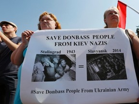 Women hold a poster during a rally to support pro-Russian separatists in Eastern Ukraine, in Russia's Siberian city of Krasnoyarsk, June 21, 2014. REUTERS/Ilya Naymushin