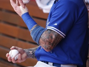 Brett Lawrie of the Toronto Blue Jays juggles three baseballs in the dugout before the game against the Cincinnati Reds at Great American Ball Park on June 21, 2014. (Joe Robbins/Getty Images/AFP)