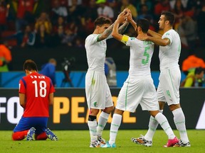 (L-R) South Korea's Kim Shin-wook reacts, as Algeria's Carl Medjani, Rafik Halliche and Essaid Belkalem celebrate at the end of their 2014 World Cup Group H soccer match at the Beira Rio stadium in Porto Alegre June 22, 2014. (REUTERS/Damir Sagolj)