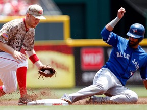 Toronto Blue Jays right fielder Jose Bautista (19) slides in safe under the Cincinnati Reds third baseman Todd Frazier (21) during the first inning at Great American Ball Park in Cincinnati June 22, 2014. (Frank Victores-USA TODAY Sports)